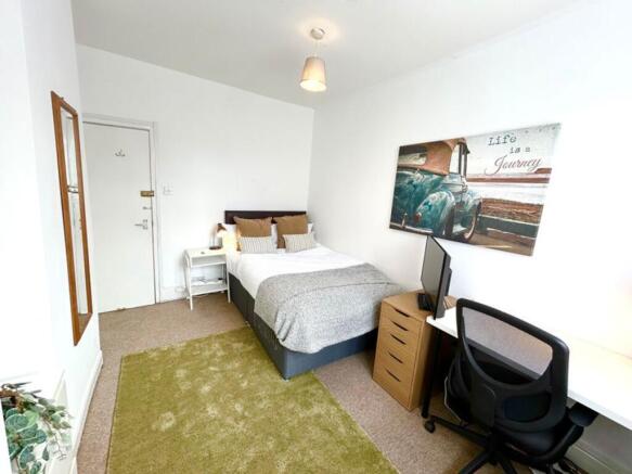 This inviting double bedroom features a comfort...