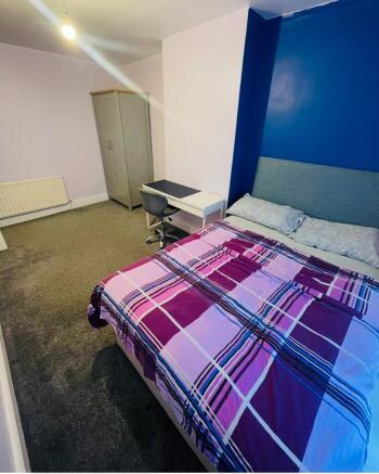 This cozy double bedroom features a comfortable...