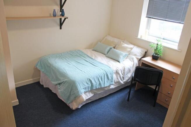 This inviting double bedroom features a cozy be...