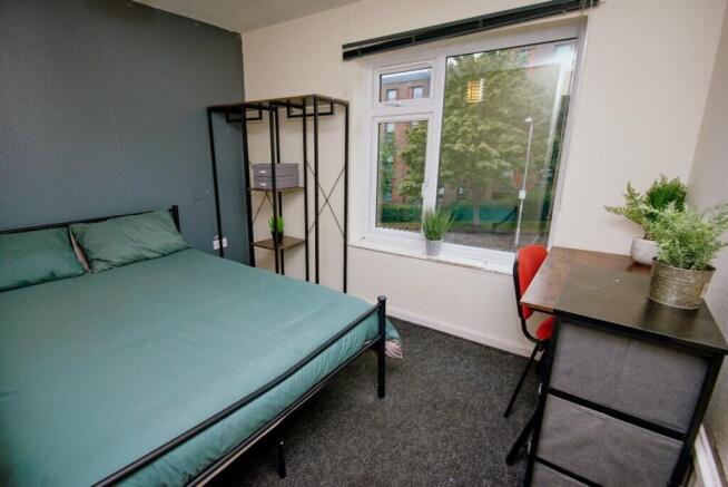 This inviting double bedroom features a spaciou...