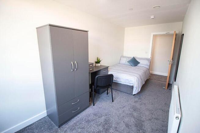 Cozy double bedroom featuring a comfortable bed...