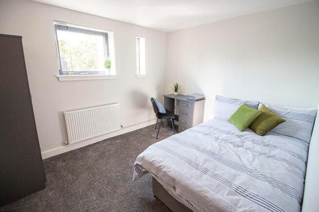 A cozy double bedroom featuring a comfortable b...