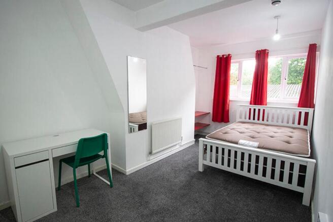 Spacious double bedroom featuring large windows...