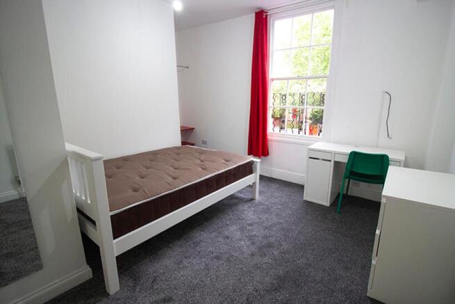 A bright and inviting double bedroom featuring ...