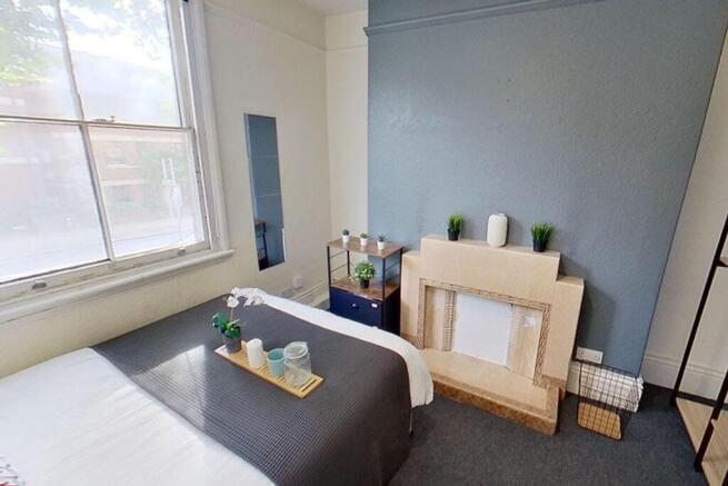 This charming double bedroom features a cozy at...