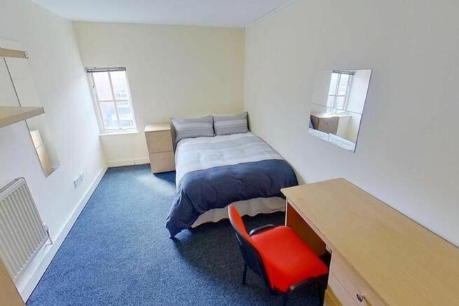 A cozy double bedroom featuring a comfortable b...