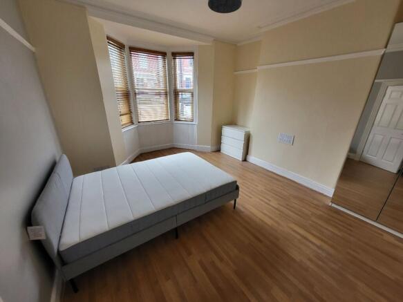 This spacious double bedroom features large win...