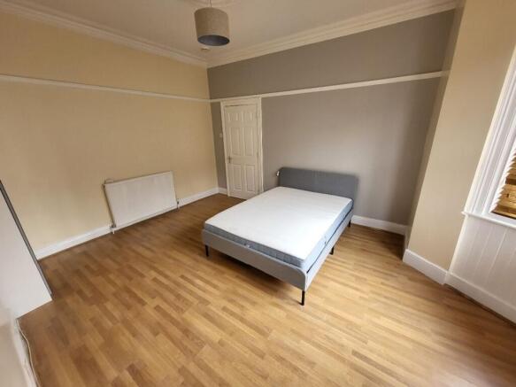 Spacious double bedroom featuring ample natural...