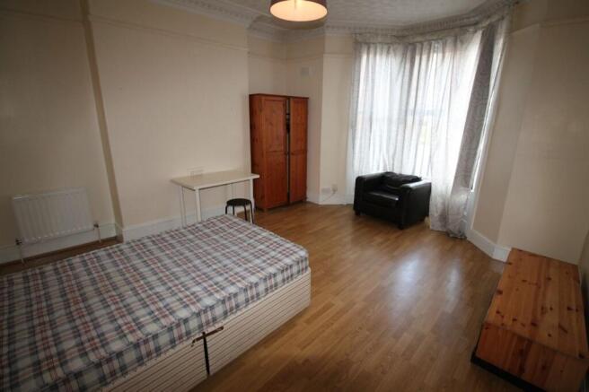 Spacious double bedroom featuring large windows...