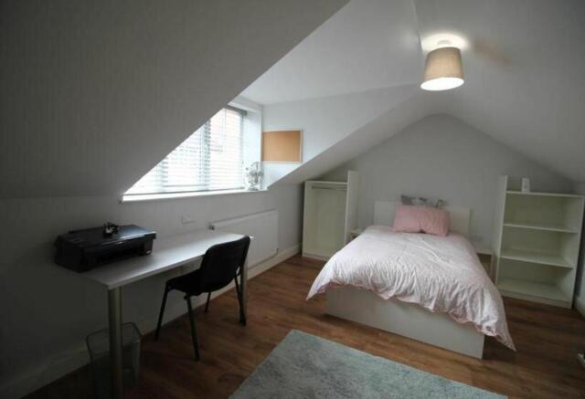 A charming double bedroom featuring a cozy bed,...