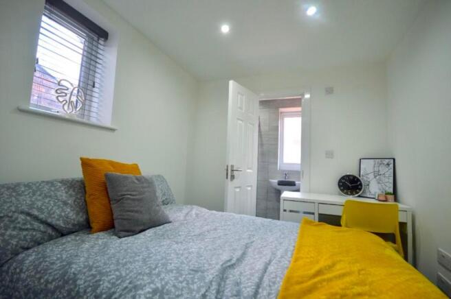 A bright and inviting double bedroom with a coz...