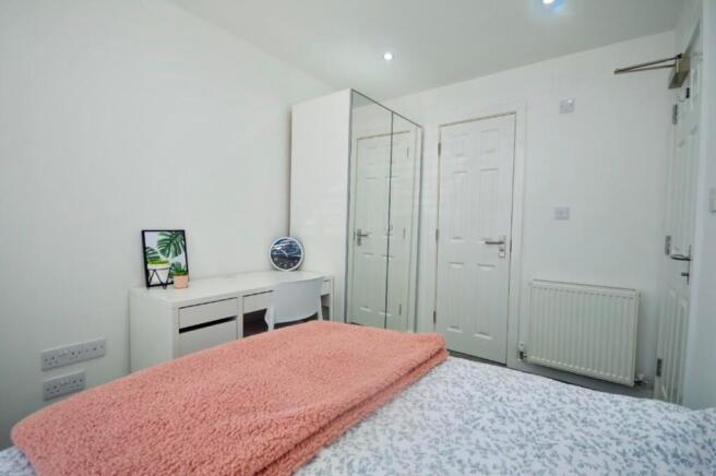 A bright and tidy double bedroom featuring mode...