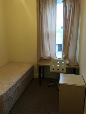Cozy and well-lit single bedroom featuring a co...