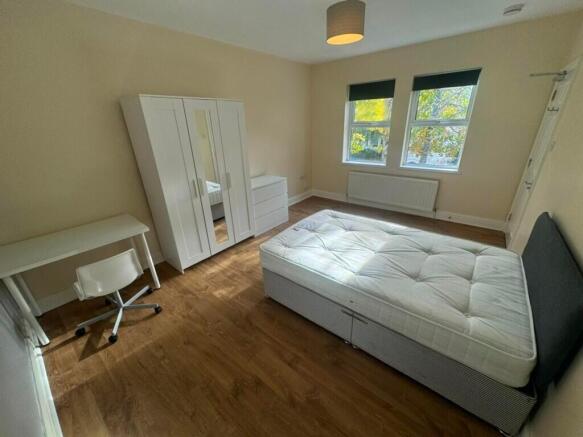 Spacious double bedroom featuring large windows...