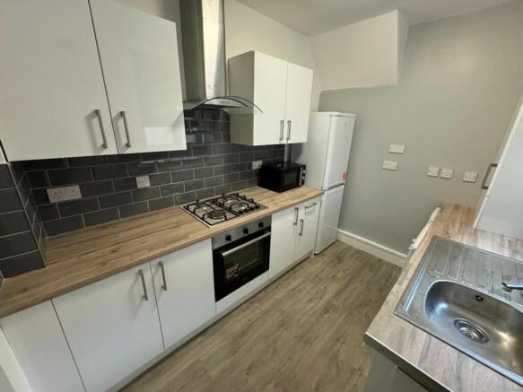 Modern kitchen equipped with sleek white cabine...