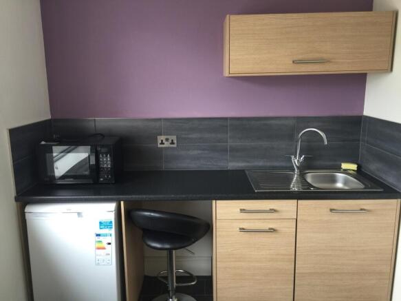 This modern kitchenette features sleek wooden c...
