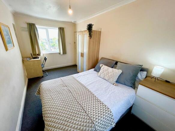 This inviting double bedroom features a cozy la...