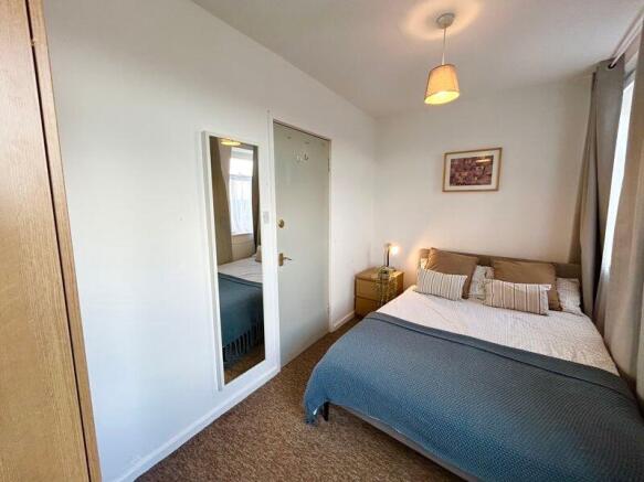 This cozy double bedroom features a comfortable...