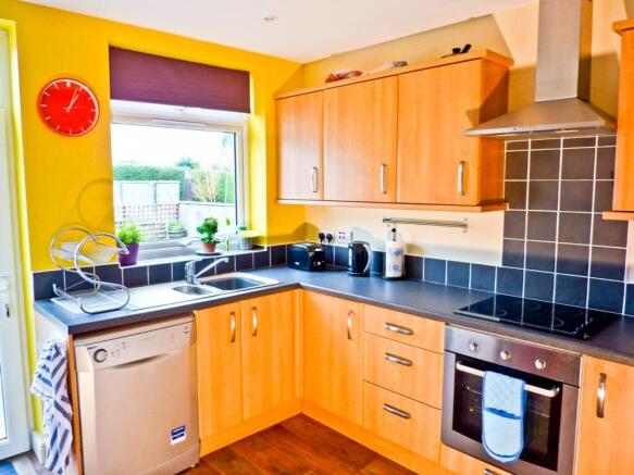 A bright and modern kitchen featuring ample sto...