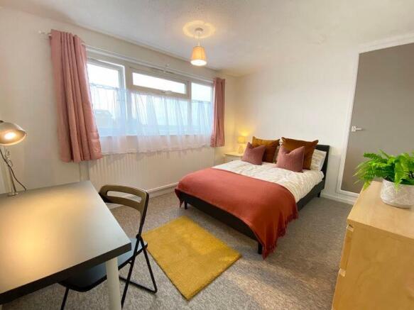 This inviting double bedroom features a cozy be...