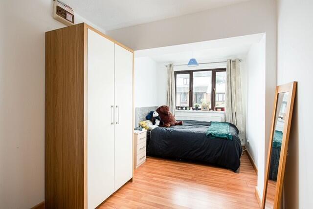 This charming double bedroom features warm wood...