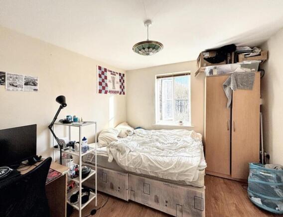 This cozy double bedroom features ample natural...