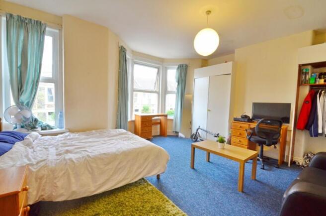 This cozy double bedroom features ample natural...
