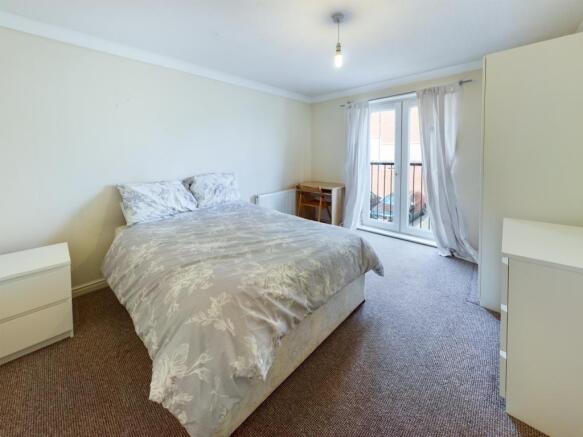 Bright and tidy double bedroom featuring a comf...