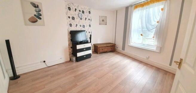 A cozy living room featuring warm wooden floori...