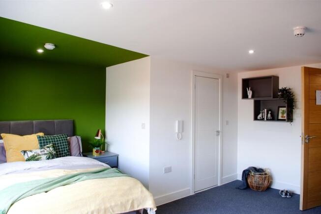 This inviting double bedroom features a cozy at...