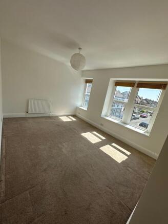 Bright and spacious living room featuring large...
