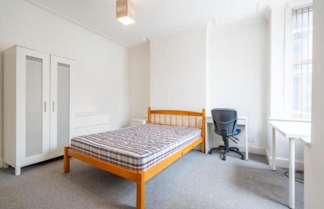 This cozy double bedroom features a spacious la...