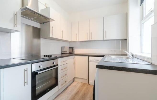 This modern kitchen features sleek cabinetry, a...