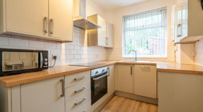This modern kitchen features sleek cabinetry, a...