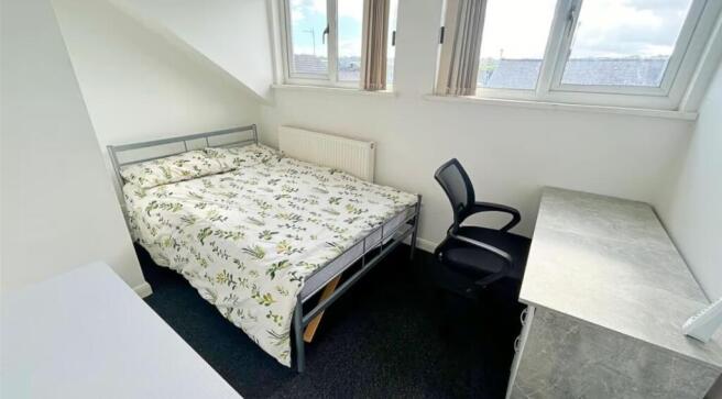 This cozy double bedroom features a comfortable...