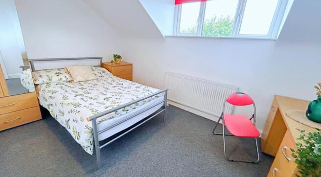 Cozy double bedroom featuring a comfortable bed...