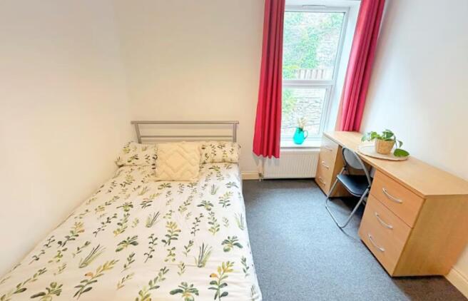 A cozy double bedroom featuring a comfortable b...