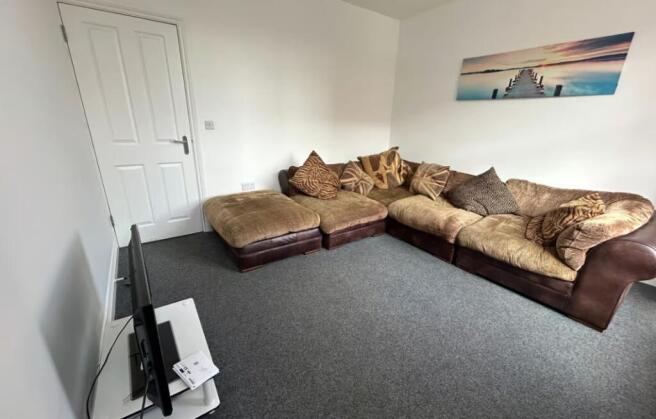 A cozy living room featuring a spacious, comfor...