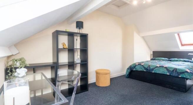 This inviting double bedroom features a cozy at...