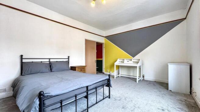 Spacious double bedroom featuring vibrant wall ...