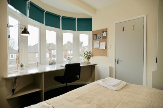 This inviting double bedroom features large win...