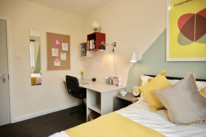 This inviting double bedroom features a cozy am...