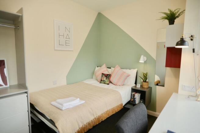 A beautifully styled double bedroom featuring a...