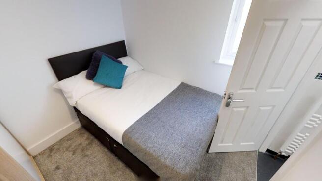 Cozy double bedroom featuring a comfortable bed...