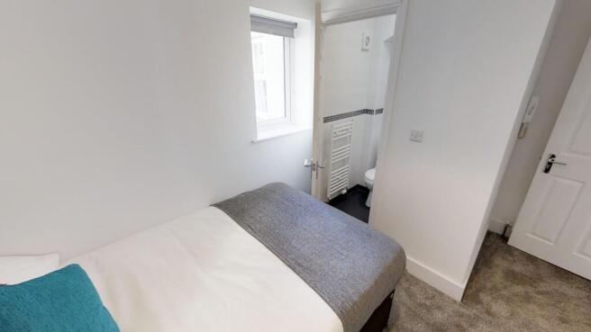 This cozy double bedroom features a comfortable...