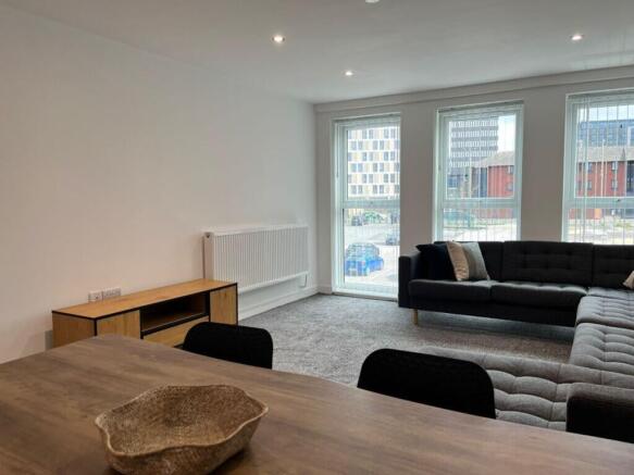 This spacious living room features large window...