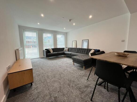 A spacious and inviting living room featuring a...