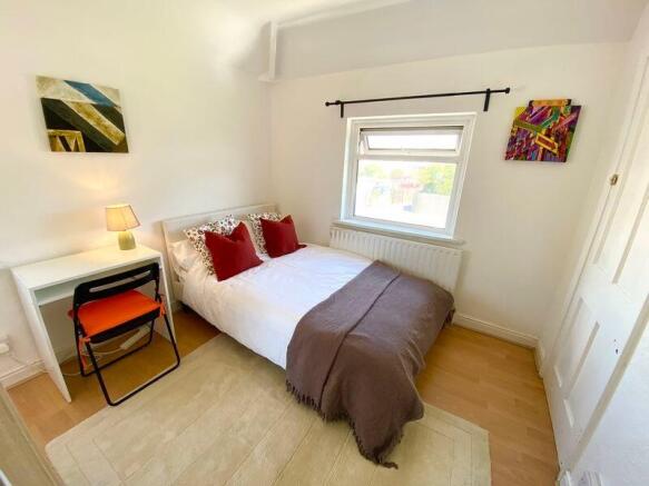 This charming double bedroom features a cozy am...
