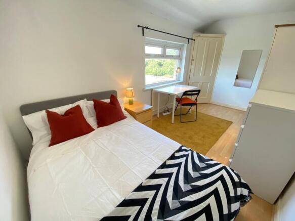 A bright and inviting double bedroom featuring ...