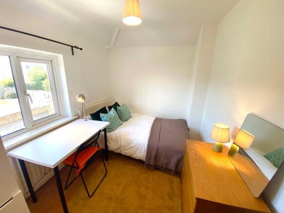 This inviting double bedroom features a cozy be...